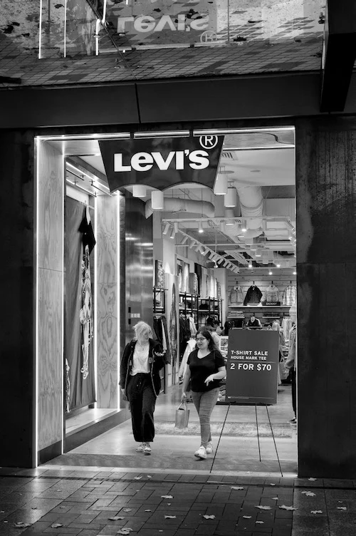 Two female shoppers leaving a Levi's store captured by photographer Peter Pickering